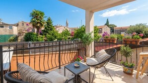 A balcony with wicker furniture, a small table, and potted plants. - Modern Apartment Larisa in Tar with Pool for 4 (Tar)