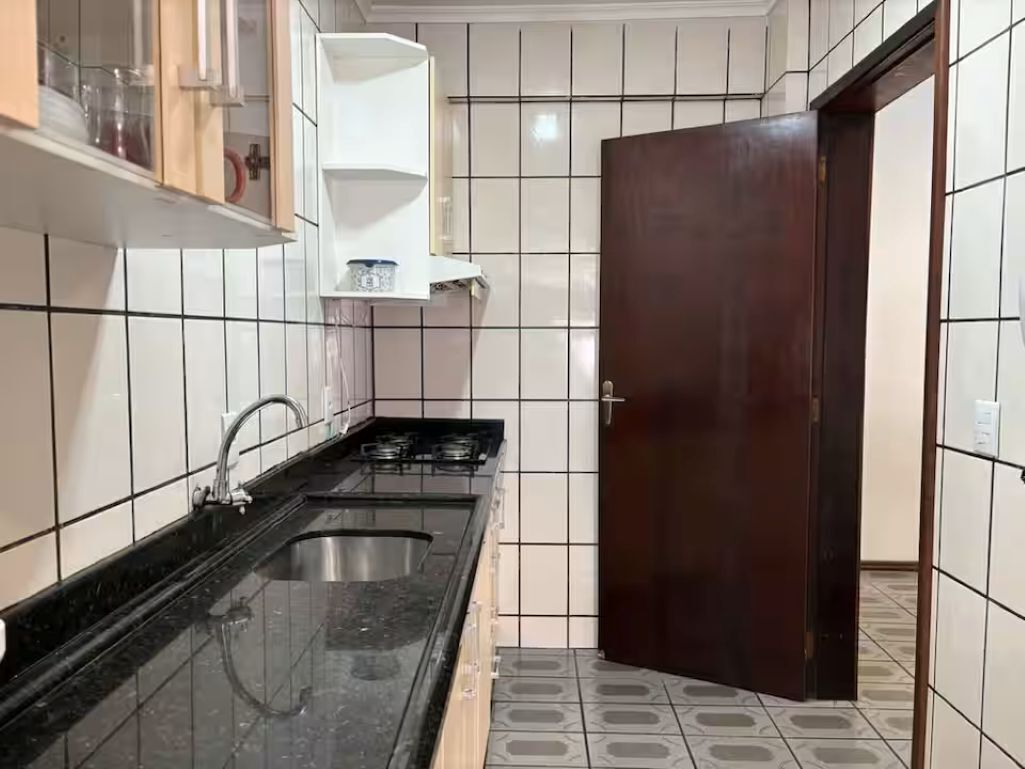 A kitchen with a sink, cabinets, and a door.