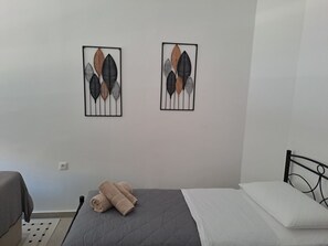Ein Schlafzimmer mit einem Bett, einem Sessel und zwei Wandbildern.