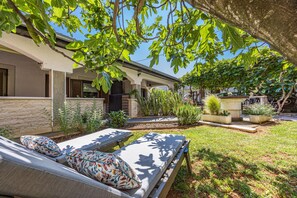 A house with a garden, a pool, and a patio with lounge chairs. - Sea Breeze Funtana Studio Apartment A10 (Funtana)