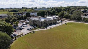 A large building with a parking lot and a grassy field. - Walton View Hotel (Bradford)
