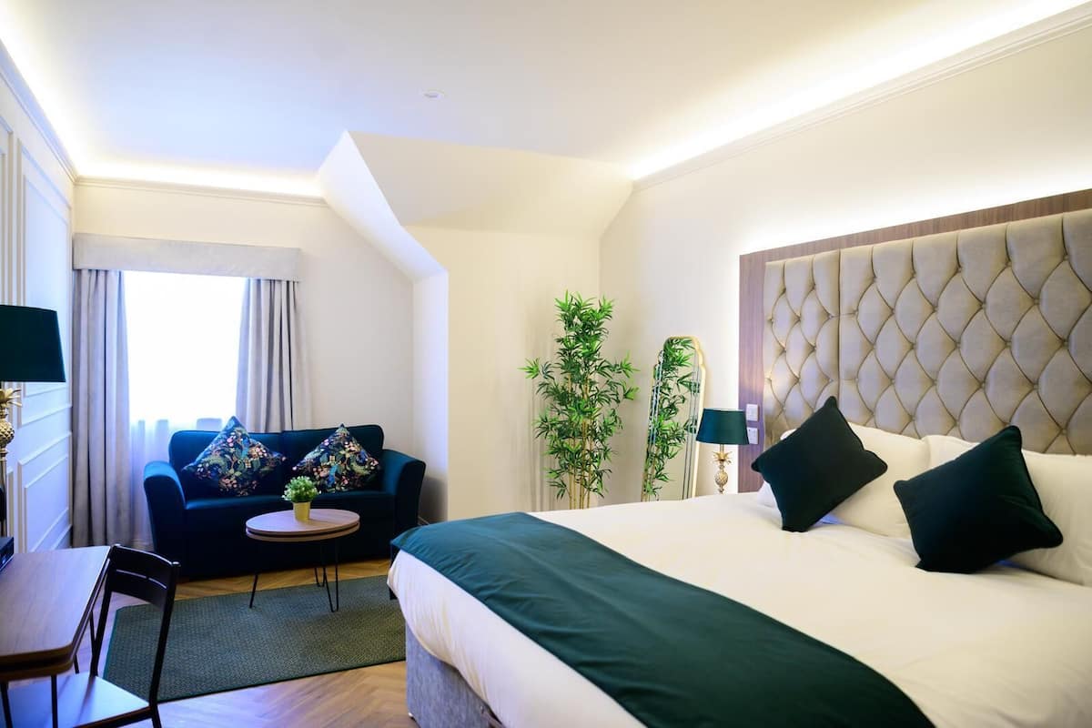 Ein Hotelzimmer mit einem Bett, einem Schlafsofa, einem kleinen Tisch und einem Sessel.