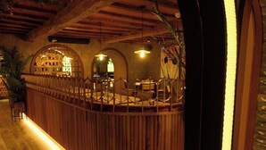 A wooden reception desk with a curved design, arched windows, and hanging pendant lights. - Walton View Hotel (Bradford)