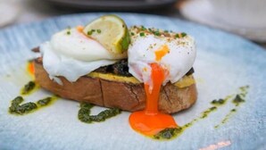 A plate with a poached egg, a slice of toast, and a drizzle of sauce. - Walton View Hotel (Bradford)