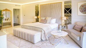 A bedroom with a large bed, a bedside table, a round coffee table, and a sofa. - Walton View Hotel (Bradford)