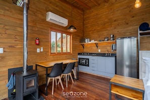 A wooden cabin interior with a kitchen, dining area, and a wood stove. - Cabin With Fantastic View and Jacuzzi Vst029 (Anitapolis)