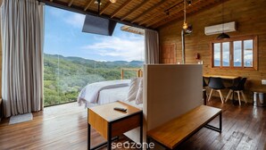A bedroom with a bed, a desk, a chair, and a view of the mountains. - Cabin With Fantastic View and Jacuzzi Vst029 (Anitapolis)