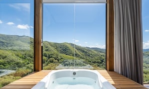 Ein Whirlpool auf einer Holterrasse mit Blick auf die Berge.