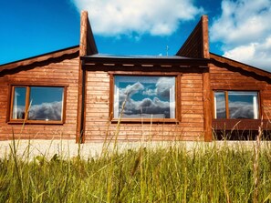 A wooden cabin with large windows, a pitched roof, and a clear sky. - No 3 (Enniskillen)