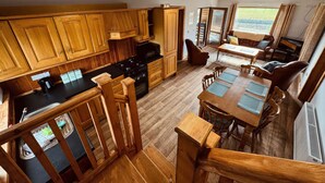 A kitchen with wooden cabinets, a dining area with a table and chairs, and a view of the outdoors.