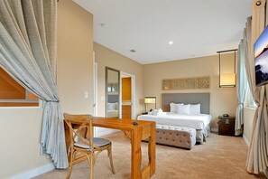 A hotel room with a bed, bedside table, chair, and a television. - Spacious Luxury 4BR Suite Near Disney (Kissimmee)