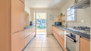 Eine moderne Küche mit Holzausstattung, einem eingebauten Ofen und einem großen Fenster.