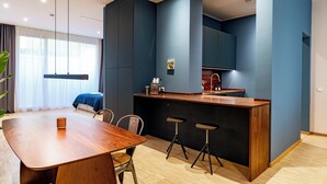 Eine moderne Küche mit einer Holztischinsel, Barhocker und einem Esstisch mit Stühlen.