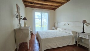 Una camera da letto con un letto, comodini, una cassettiera e una finestra con vista.