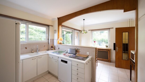 Una cocina con lavavajillas, microondas y ventana.