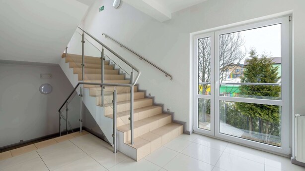 A modern interior with a staircase, a large window, and a visible exit sign. - Cozy Studio close to the Beach | Balcony | Parking (Grzybowo)