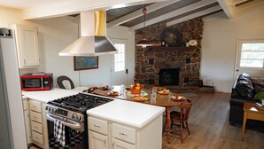 Une cuisine équipée d’une cuisini ère, d’un four à micro-ondes et d’un coin repas avec une table et des chaises.