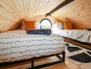 Acogedor dormitorio en ático con cama, ventana y vistas al exterior.