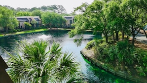 A tranquil water body surrounded by lush greenery and modern buildings. - Island Club 106 | Pool, Hot Tub, Tennis & Beach (Hilton Head Island)