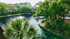 A tranquil water body surrounded by lush greenery and modern buildings. - Island Club 106 | Pool, Hot Tub, Tennis & Beach (Hilton Head Island)