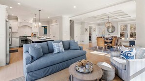 A spacious living area with a sofa, coffee table, and dining table. - Upscale Beach Retreat w Pool, Half Mile to Beach! (Dennis)