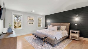 A bedroom with a bed, bedside tables, a bench, a dresser, and a TV. - Upscale Beach Retreat w Pool, Half Mile to Beach! (Dennis)