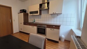 A compact kitchen with a microwave, oven, and sink. - Cozy 1 bedroom apartment in a quaint Chemnitz neighborhood (Chemnitz)