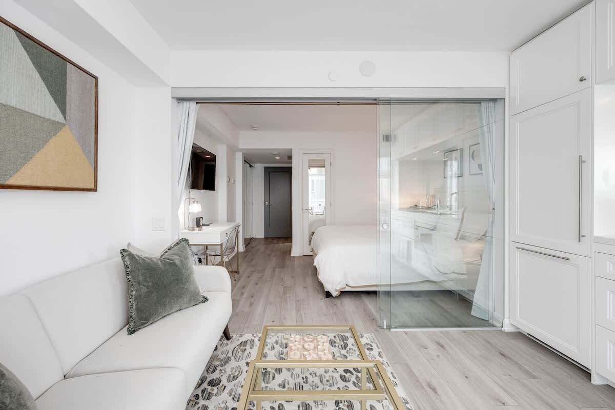 Comfortable bed with hotel-quality linens in a bright open sleeping area.