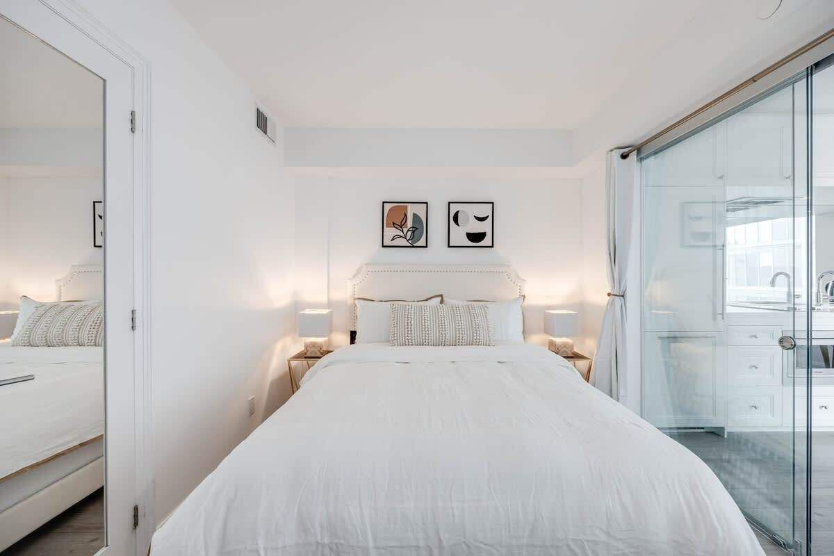 Comfortable bed with hotel-quality linens in a bright open sleeping area.