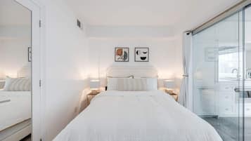 Comfortable bed with hotel-quality linens in a bright open sleeping area.