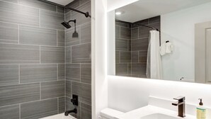Une salle de bain moderne équipée d’une baignoire, d’une douche et de toilettes.