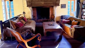 A cozy living room with a fireplace, wooden furniture, and a bookshelf. - Former mill of the Château de Bourbilly transformed into a pretty country house (Vic-de-Chassenay)