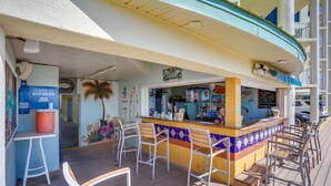 A bar area with a counter, chairs, and a Bud Light cooler. - Sunset Vistas 302n (Treasure Island)