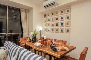 Un comedor con una mesa de madera, sillas y una pared decorada con cuadros.
