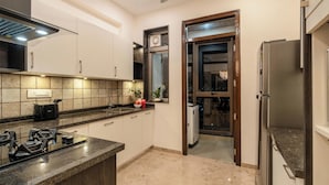 Una cocina moderna con estufa a gas, horno empotrado y refrigerador.