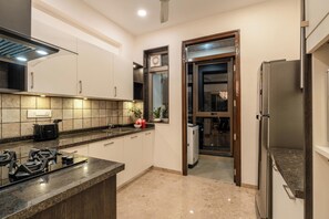 A modern kitchen with a gas stove, a built-in oven, and a refrigerator.