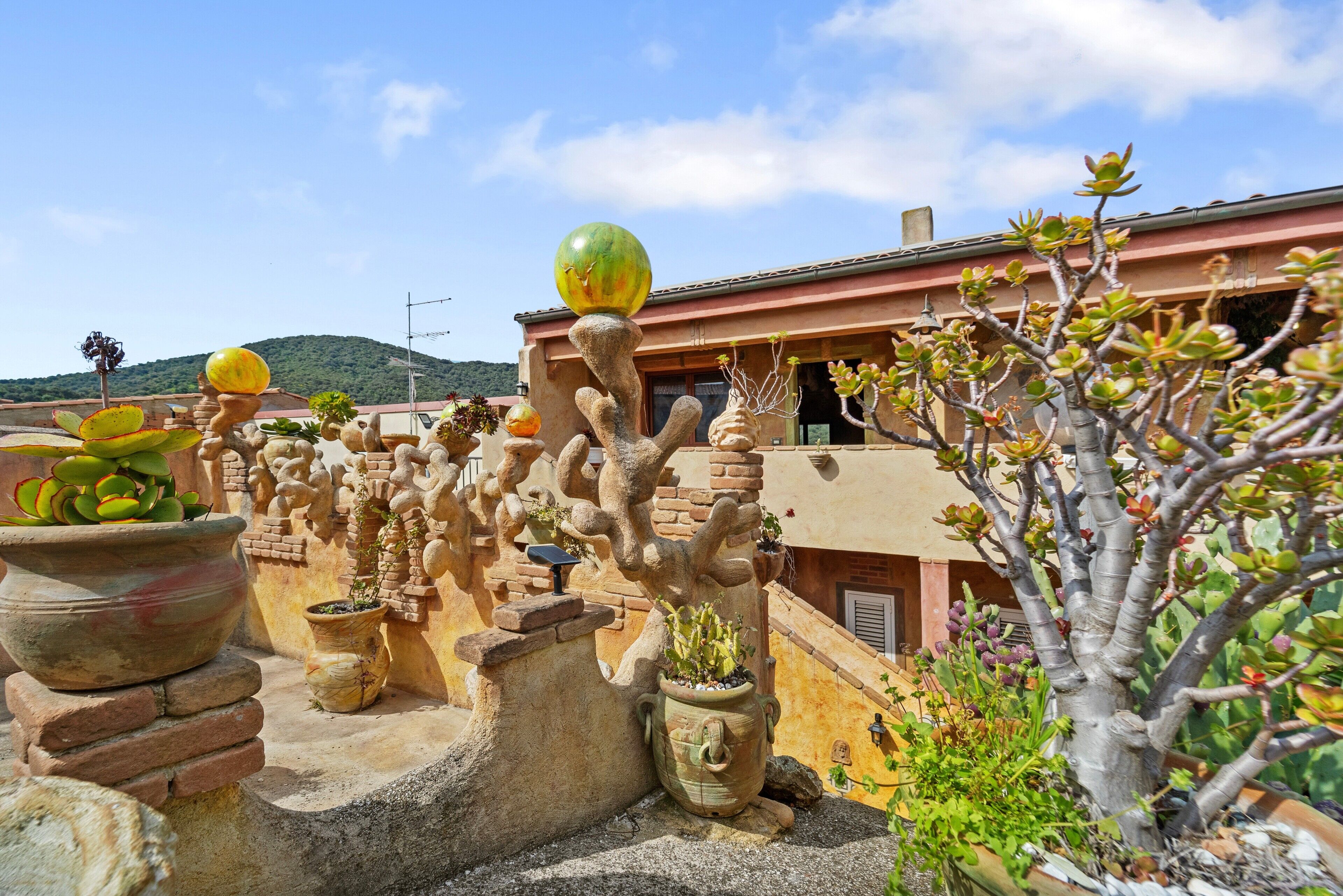 A rooftop garden with potted plants and a unique tree sculpture.