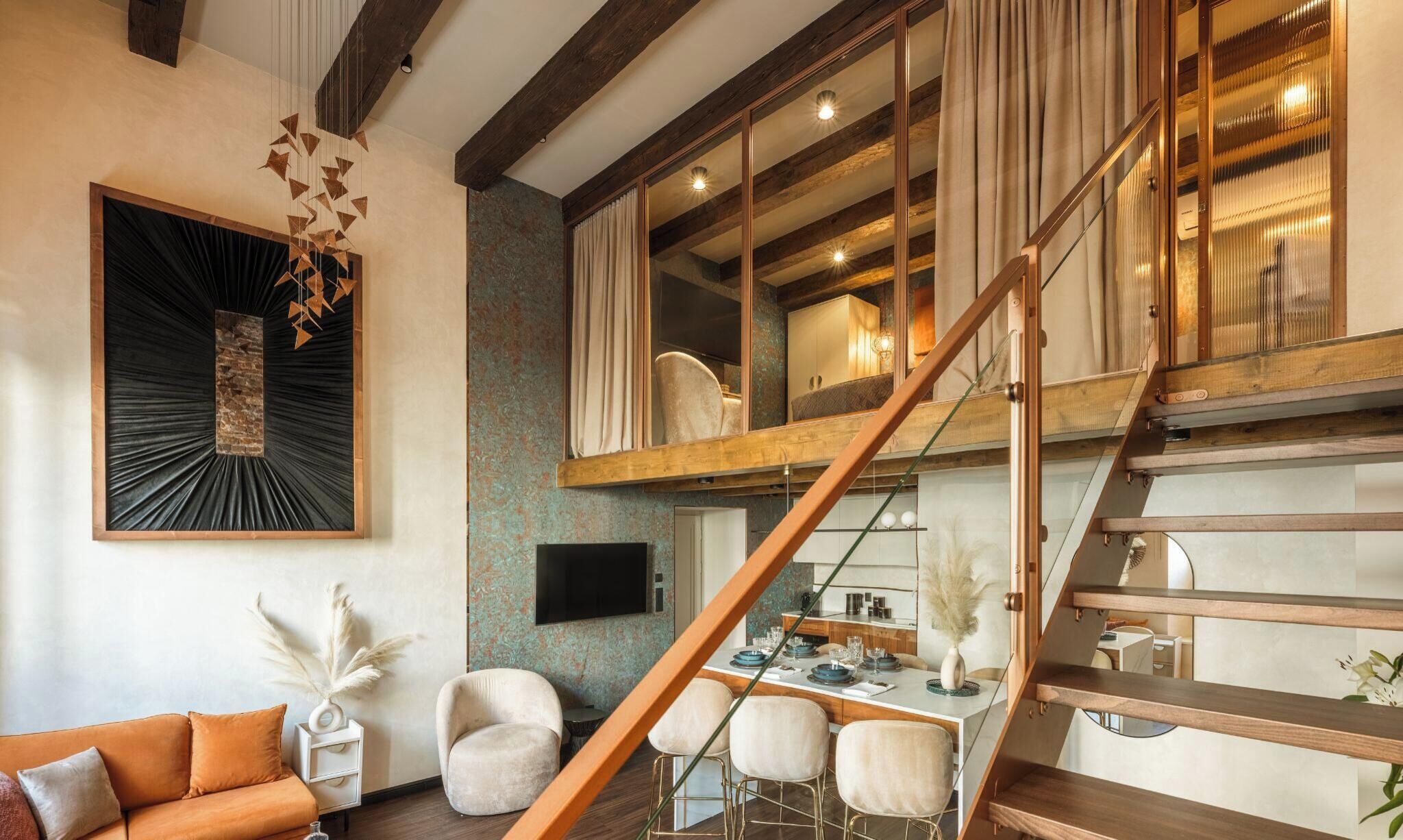 A modern interior with a dining area, a staircase, and a living room with a sofa and decorative items.