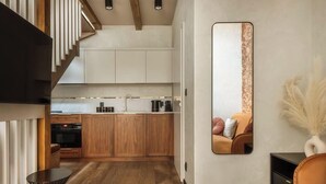 Een moderne keuken met houten kasten, een inbouwoven en een aanrecht met keukenapparatuur.