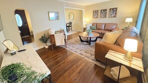 Ein Wohnzimmer mit einer Couch, einem Couchtisch und einem Essbereich mit Tisch und Stühlen.