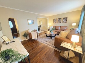Ein Wohnzimmer mit einer Couch, einem Couchtisch und einem Essbereich mit Tisch und Stühlen.