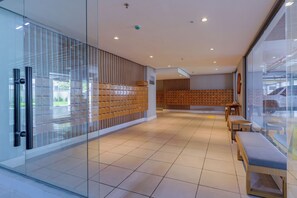 A modern interior with glass partitions, wooden lockers, and seating areas. - Charlie Rio Energy Porto Maravilha (Rio de Janeiro)