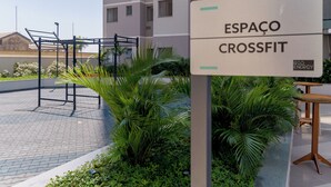 A sign for 'ESPAÇO CROSSFIT' with a metal workout structure and greenery in the background. - Charlie Rio Energy Porto Maravilha (Rio de Janeiro)
