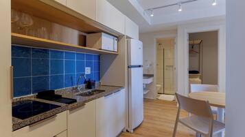 Una cucina moderna con forno a microonde integrato, lavello e zona pranzo con tavolo e sedie.