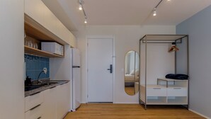 A modern kitchen with white cabinets, a microwave, and a sink. - Charlie Rio Energy Porto Maravilha (Rio de Janeiro)