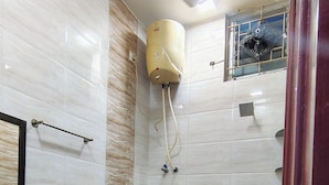 A bathroom with a toilet, bidet, sink, and a ceiling fan. - Hotel Rayas (Kumbakonam)