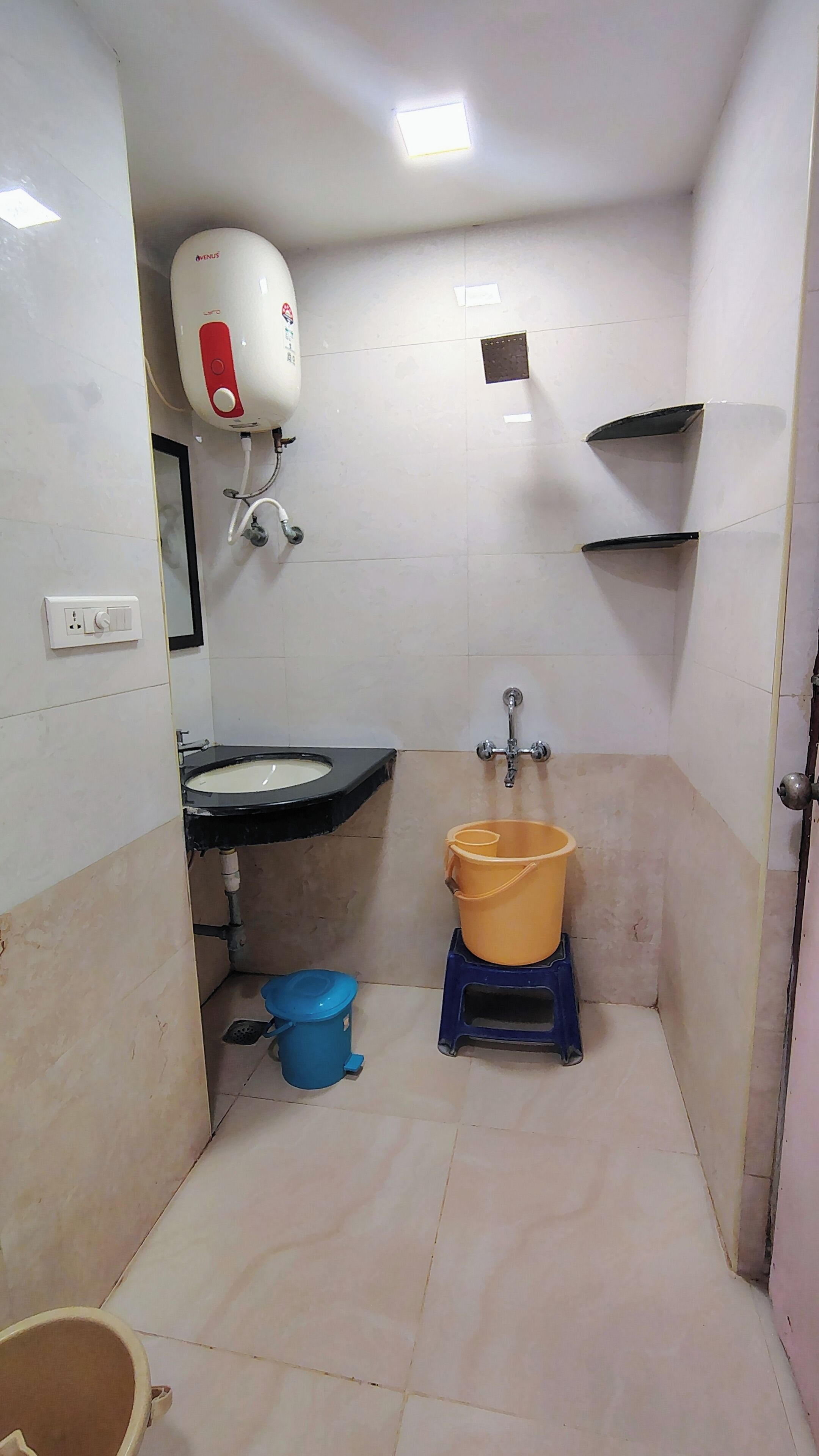 A small bathroom with a sink, a toilet, a shower, and a water heater.