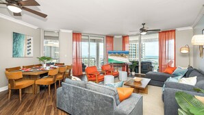 Ein geräumiger Wohnbereich mit Esstisch, Sofas und Fernseher.