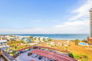 Ein Hotel an der Küste mit Blick auf den Strand, einem Parkplatz und einem Pool.
