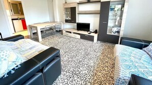 Una camera d'albergo funzionale con un letto, una scrivania, una TV e un armadio.